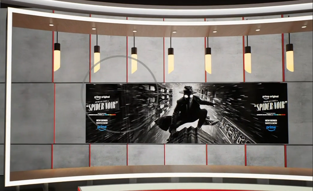 Black-and-white Spider-Noir poster on a grey studio wall with hanging lights above, part of a news-set backdrop.
